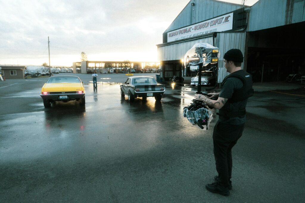 man in black jacket standing beside black car during daytime